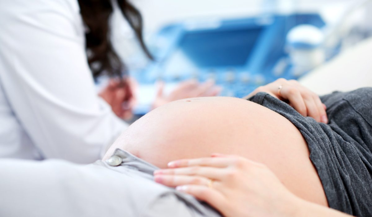 Cropped close up of a pregnant woman waiting for her doctor to start ultrasound scanning procedure at the hospital copyspace pregnancy expecting mother children healthcare family gynecology diagnosis.